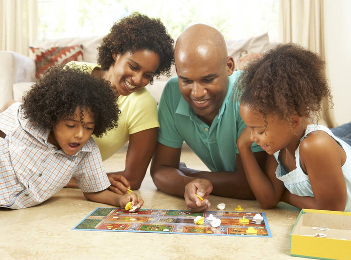 There is a family playing a board game on the floor.